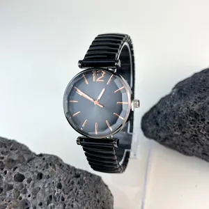 Vista detallada de un reloj de cuarzo para mujer con esfera negra y correa elástica.