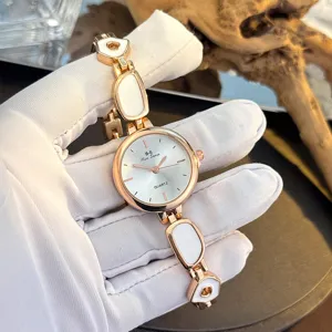 Details zur Damenuhr mit unregelmäßigem Gliederarmband, weißen Einlagen und Zifferblatt.