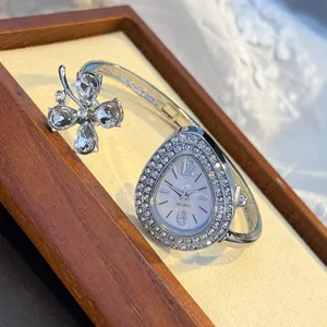 Close-up detail of luxury silver crystal teardrop quartz watch with elegant clover design.