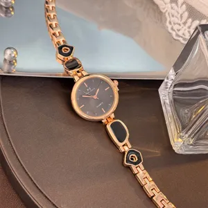 Detailansicht der Damen Quarzuhr, roségoldenes Metallarmband mit schwarzen geometrischen Gliedern.