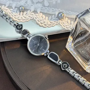 Damen Quarzuhr mit dunklem Zifferblatt und unregelmäßigem Metall Glieder Armband.