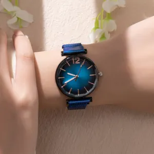 Primo piano di un elegante orologio al quarzo blu con cinturino in maglia al polso.