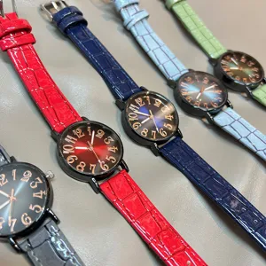 Detalles en primer plano de relojes de mujer con esferas degradadas y correas de cuero texturizado.