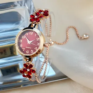 Exquisite close up of women quartz watch featuring red rhinestone flowers and sleek bracelet.