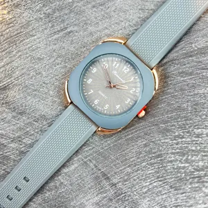 Nahaufnahme einer quadratischen Quarzuhr mit grauem Silikonarmband und Roségoldgehäuse.