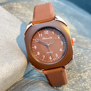 Modische Quarzuhr mit rechteckigem Metallkanten-Gehaeuse und braunem Silikonarmband.