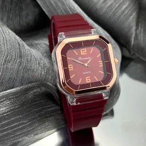 Vista detallada del reloj de cuarzo cuadrado con correa de silicona roja y bisel dorado.