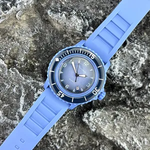 Nahaufnahme Detail einer blauen Silikon-Quarzuhr präsentiert auf strukturiertem Stein.