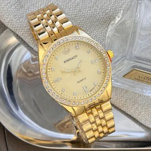 Luxus goldene Quarzuhr mit funkelnder Strasslünette und metallischem Armband im Detail.
