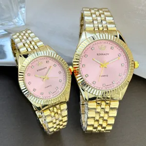 Goldfarbene Quarz-Paaruhren im Detail, elegante rosa Zifferblätter mit glänzenden Strassmarkern.