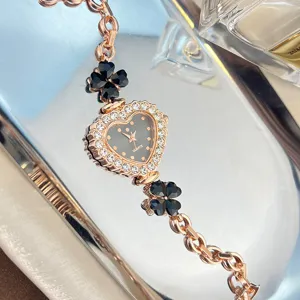 Women's rose gold quartz watch with heart rhinestone dial and black clover bracelet design.