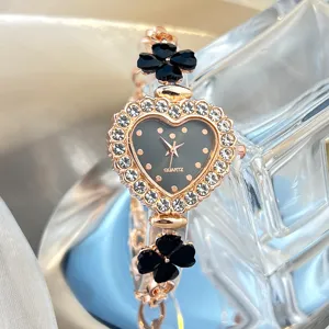 Detail view of the heart-shaped rhinestone quartz watch featuring black clover motifs.