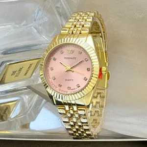 Nahaufnahme Detail der Luxus Gold Quarz Uhr mit rosafarbenem Zifferblatt und funkelnden Steinen.