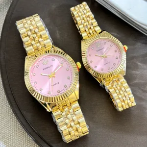 Elegantes goldenes Quarz Paare Uhrenset mit rosa Zifferblatt und funkelnden Kristallindizes.