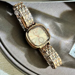 Close-up of the elegant faceted glass square quartz watch dial and rose gold metal link band.