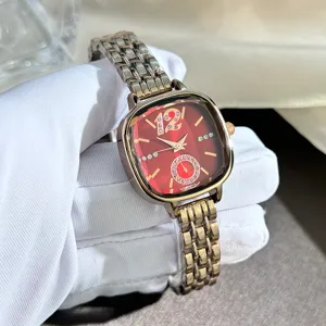 Luxury faceted glass square quartz women watch detail shot with red crystal dial and metal strap.