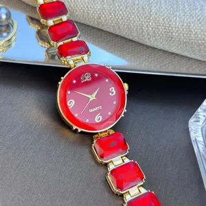 Close-up van het dames quartz horloge met rode ronde wijzerplaat en rode kristallen schakels.