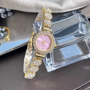Close-up of a glamorous rhinestone bracelet watch with a pink dial and crystal flower links.