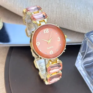 Detailopname van dames kwartshorloge met roze kristallen en gouden schakelarmband.