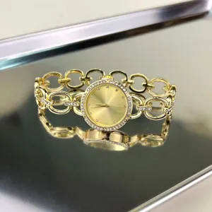 Nahaufnahme Detail einer luxuriösen goldenen Damen Kette Quarzuhr mit glänzenden Kristallen.