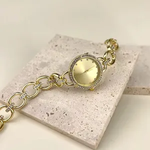 Nahaufnahme der goldenen Damen Strass Quarzkettenuhr mit glitzernder Lünette und Gliederarmband.