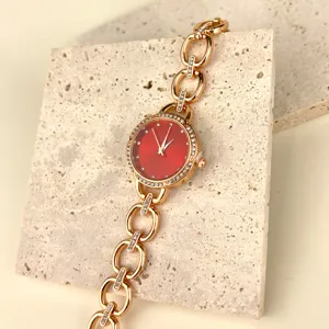 Nahaufnahme der luxuriösen Damen Quarz Armbanduhr mit rotem Zifferblatt und Kette.