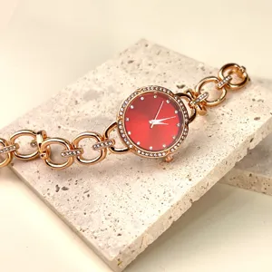 Elegante roségoldene Strass Damen Quarzarmbanduhr mit rotem Zifferblatt und Gliederarmband.