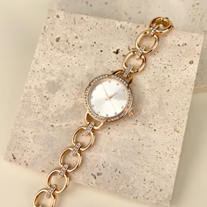 Nahaufnahme Detail einer goldenen Damen-Quarzuhr mit Strass-Lünette und Gliederarmband.