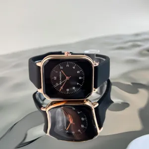 Detail shot of a square rose gold quartz watch with black dial and smooth silicone strap.