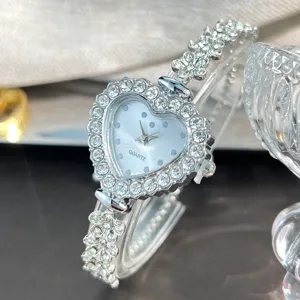 Nahaufnahme einer atemberaubenden silbernen herzförmigen Strass Damen QuarzUhr mit Blumenarmband.