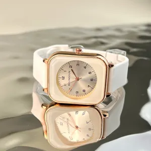 Close-up details of square quartz watch featuring rose gold case and white silicone strap.
