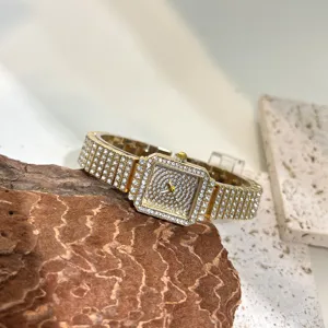 Women square rhinestone quartz watch, luxury gold bling wristwatch detail shot for fashion styling.