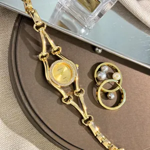 Detailansicht der luxuriösen goldenen Damenuhr mit Strasslünette und elegantem Armband.