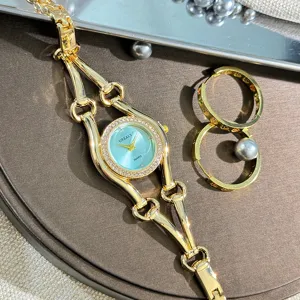 Nahaufnahme einer luxuriösen Damen Quarzarmbanduhr mit goldenem Kettenarmband und blauem Zifferblatt.