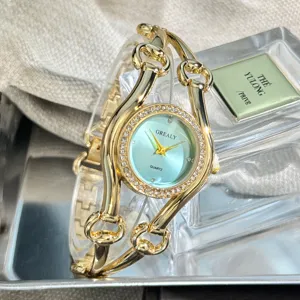 Detailaufnahme einer goldenen Quarzuhr mit einzigartigem Armband und hellblauem Zifferblatt.