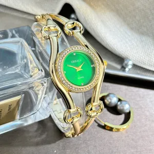Elegante Damenuhr mit grünem Zifferblatt, Kristalllünette und goldenem Pferdegebiss-Armband.