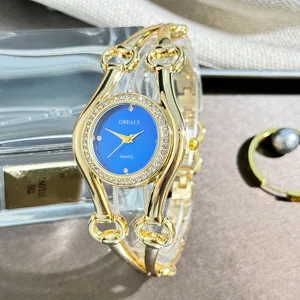 Elegante goldene Damenuhr mit blauem Zifferblatt und funkelnden Strass-Luenettendetails.