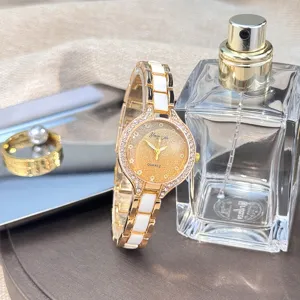 Gold white ceramic women quartz watch detail shot, luxury rhinestone bezel sparkly dial.
