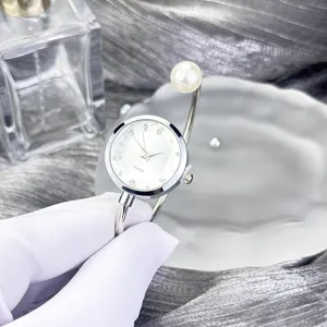 Elegante Perlen-Manschetten-Quarzuhr mit glitzernden Strasssteinen und schickem Silber-Armreif.