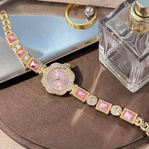 Detailed view of women luxury crystal quartz watch with pink gemstone bracelet and floral dial.