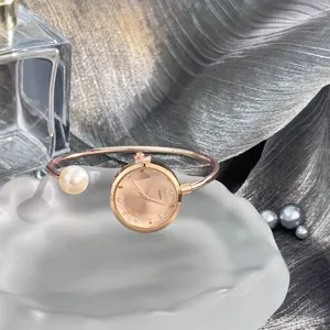 Detailansicht der roségoldenen Armband-Quarzuhr mit Perlenakzent und facettiertem Zifferblatt.