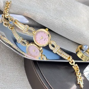 Detailansicht der goldenen Quarz-Armbanduhr mit Strass, elegante rosa Zifferblatt-Uhr.