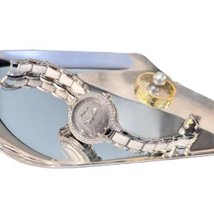Luxury women quartz watch with glittering starry dial and ceramic bracelet on silver tray.