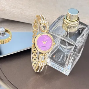 Detailaufnahme einer goldenen Damen Strass Armbanduhr mit Quarzwerk und rosa Glitzerzifferblatt.
