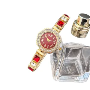 Women's luxury rhinestone quartz watch with red crystal gemstone bracelet and floral dial.