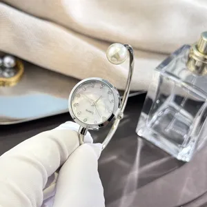 Elegante Quarz-Armreif-Uhr mit Perlen-Detail, funkelnden Strasssteinen und Perlmutt-Zifferblatt.