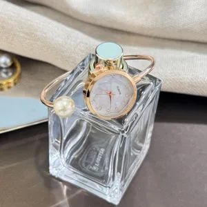 Detailansicht einer französischen romantischen Perlen-Armreif-Uhr mit glitzerndem Zifferblatt.