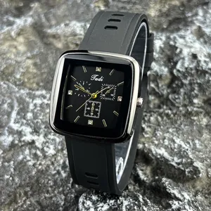 Nahaufnahme der schwarzen quadratischen Quarzuhr mit Silikonarmband und goldenen Indizes.