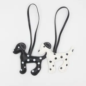 Nahaufnahme von schwarz-weißen Pünktchen PU-Leder Welpen Taschenanhänger mit Schlaufe.