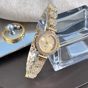 Detailed view of women gold rhinestone watch, sparkling crystal dial and floral bracelet strap.